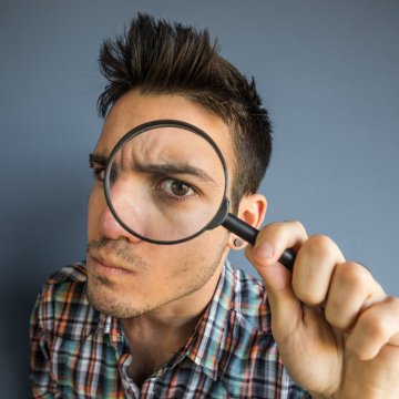 us search online background check service features man looking through magnifying glass